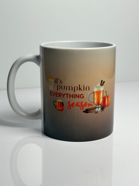 A beige and brown ceramic mug with a handle, featuring pumpkin spice latte.